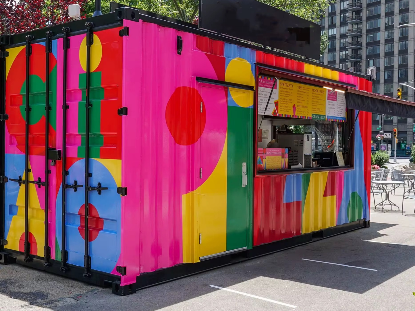 Colorful food container unit with abstract patterns on a street