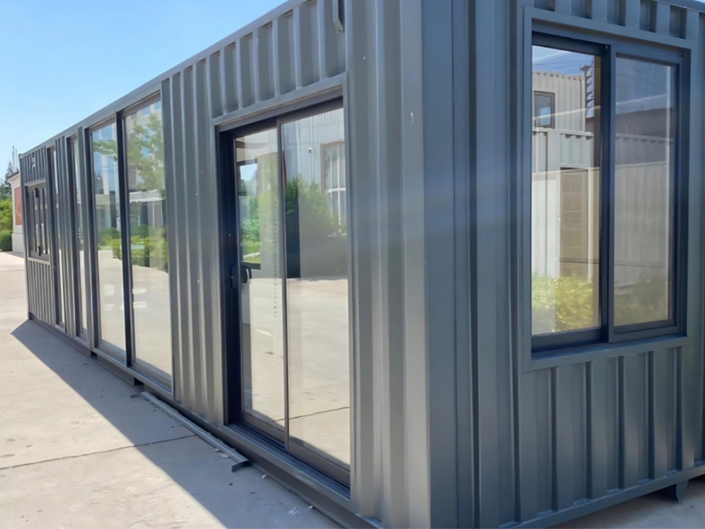 Modular building with glass walls and metal frame on a clear day