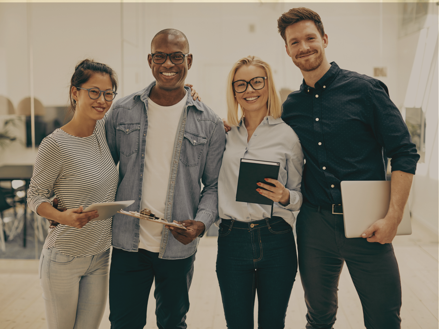Four people standing together holding documents in an indoor setting