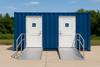Blue shipping container with white doors featuring wheelchair accessibility symbols, set against a natural background.
