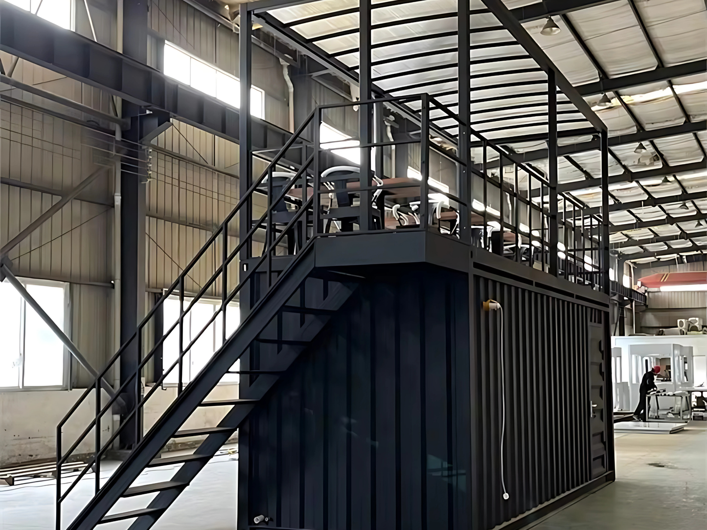 Modern industrial interior with metal staircase and container shop setup.