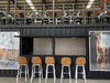 Container bar area with stools and wall art in a modern interior setting