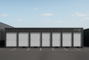 Row of storage units built using container with white doors on a clear day