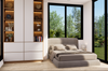 Modern bedroom with a bed, shelves, and large windows showing greenery outside.