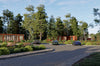 Road with cars and a scenic background of trees and container apartments.
