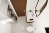 Top-down view of a modern bathroom with white tiles, wooden cabinets, and a sink.