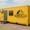 Yellow shipping container home with Borcelle Construction logo on a clear day