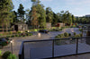 Gated community with cars, pathways, and greenery. All homes are made with shipping containers. 