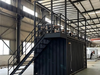 Modern industrial interior with metal staircase and container shop setup.