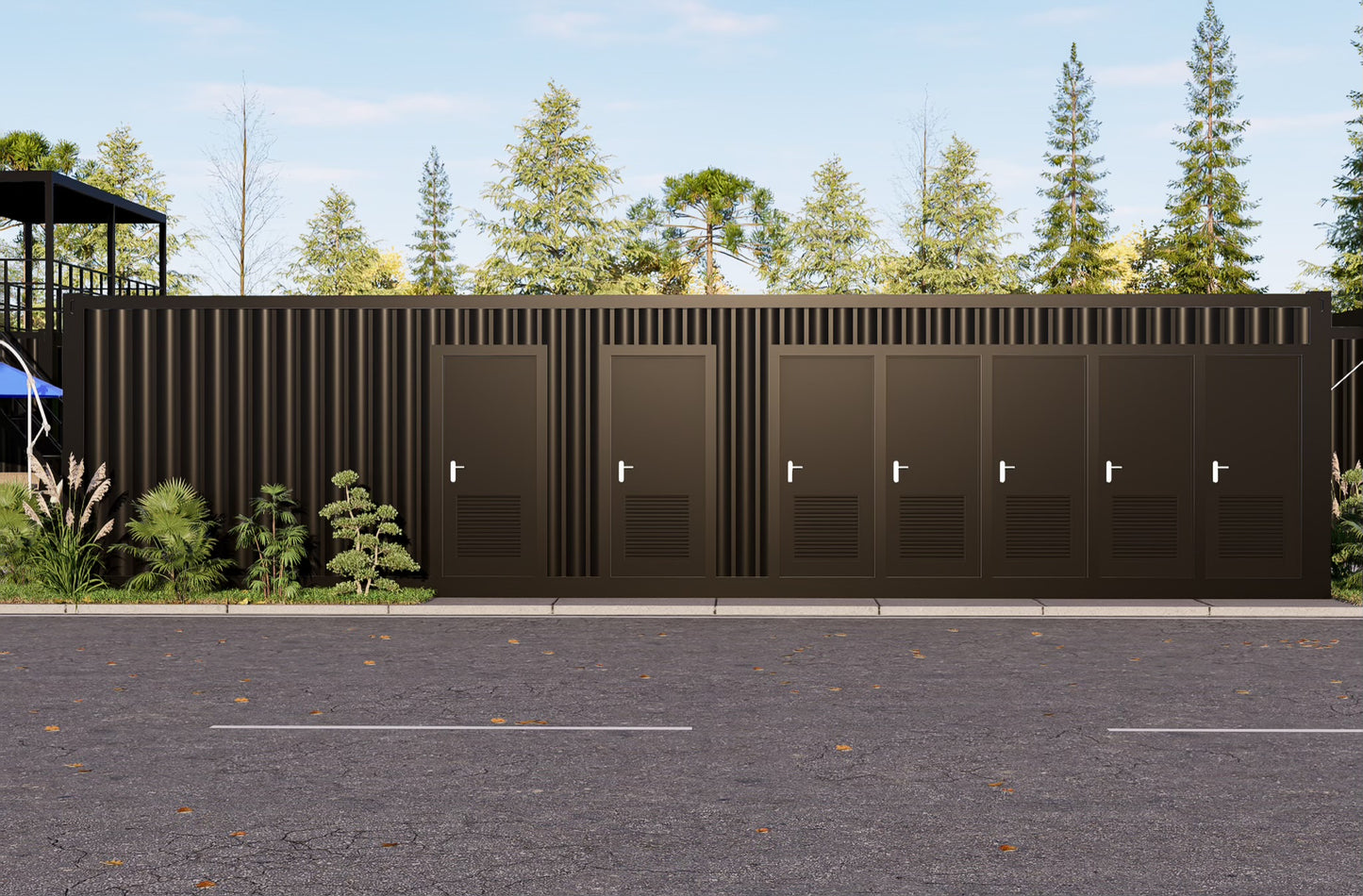 Row of dark brown containers restrooms with metal doors on a paved area with trees in the background.