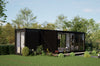 Modern black container house with glass doors in a green, tree-lined setting