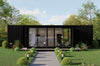 Modern black container house with large glass windows in a green, tree-lined setting.