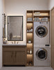Modern bathroom with wooden vanity, mirror, and stacked washer and dryer.